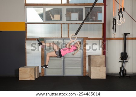 Woman swinging in the air with gymnastics rings - fitness training