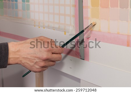 Artist is painting a picture - squares using a paint brush