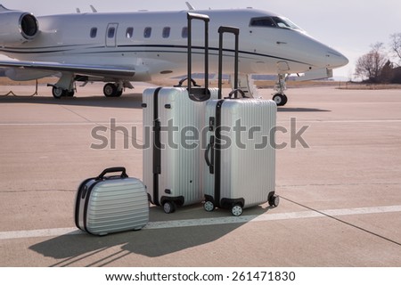 luggage in front of a corporate jet airplane