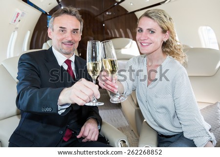business team traveling in corporate jet and drinking champaign