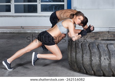 man and woman on a tire fitness training warm up