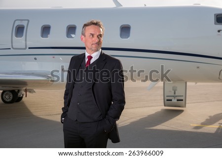 executive business man in front of corporate jet