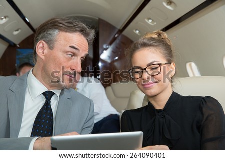 business team traveling in corporate jet and discussing a presentation
