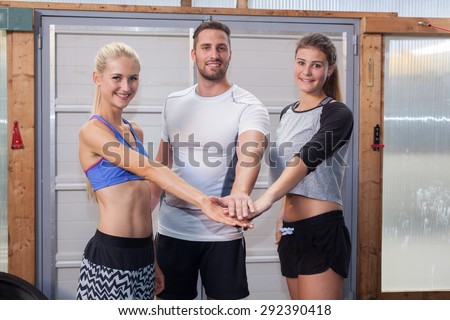Hands together - fitness team in a gym