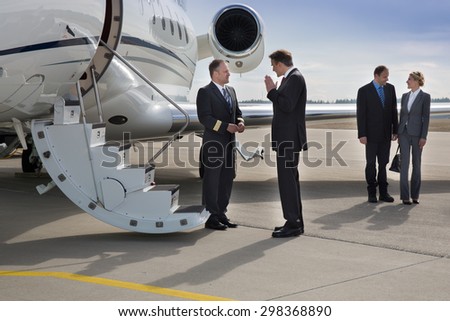 executive manager instructing pilot of corporate jet