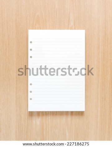White notebook paper background on wood texture.