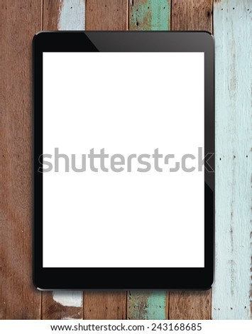 Digital tablet with blank screen area for copy space on vintage wooden background.