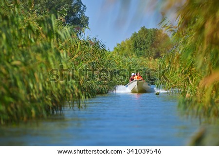 TULCEA, ROMANIA - SEPTEMBER, 2015:Unidentified people take boat trip with a local ranger in the Danube Delta Biosphere Reserve. Danube delta is the second largest river delta in Europe.