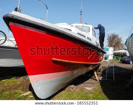 FAVERSHAM, KENT/UK - MARCH 29, 2014 : Unidentified man painting his boat in Faversham Kent on March 29, 2014