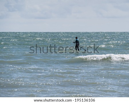 BRIGHTON, EAST SUSSEX/UK - MAY 24 : People paddle boarding at Brighton East Sussex on May 24, 2014. Unidentified man.