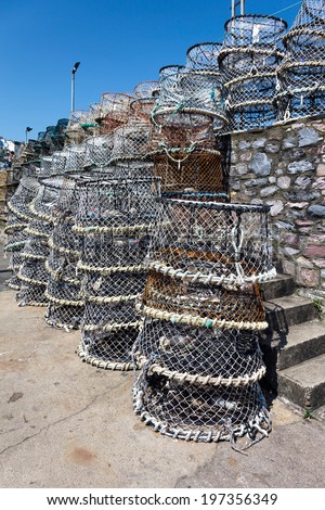 BRIXHAM, DEVON/UK - JULY 28 : Lobster pots stacked against the harbour wall in Brixham Devon on July 28, 2012