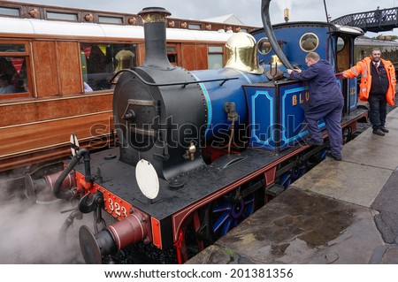 SHEFFIELD PARK, EAST SUSSEX/UK - SEPTEMBER 8 : Bluebell steam engine taking on water at Sheffield Park station East Sussex on September 8, 2013. Unidentified people.