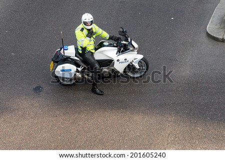 LONDON - JUNE 25 : Metropoliatan Police traffic officer clearing the way for a VIP in London on June 25, 2014. Unidentified man.