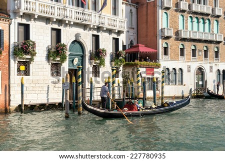 VENICE, ITALY/EUROPE - OCTOBER 12 : Gondolier ferrying a passenger along the Grand Canal in Venice Italy on October 12, 2014. Unidentified people.