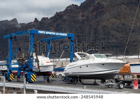 LOS GIGANTES, TENERIFE/SPAIN - JANUARY 22, 2015 : Boats being cleaned in Los Gigantes marina Tenerife Spain on January 22, 2015. Unidentified person.