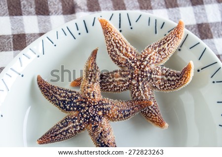 Boiled edible starfish on the plate on a table