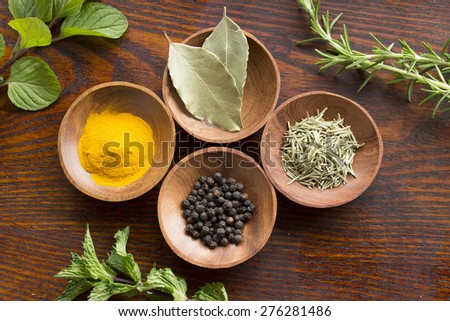 Dry herb served in wooden plate, rosemary, bay leaf, black pepper, turmeric, flesh mint, rosemary