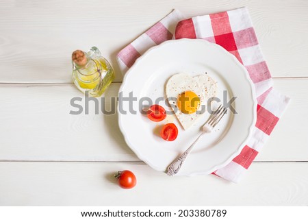 Heart Shaped Egg on the plate with tomatoes in Breakfast