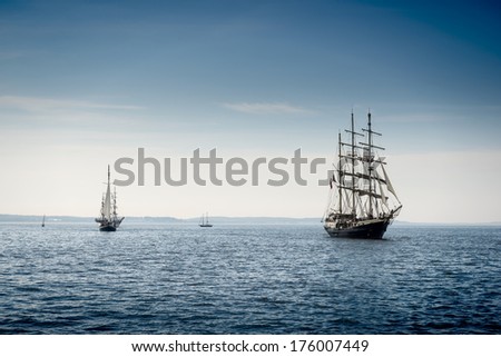 Tall ship sailing on blue water.