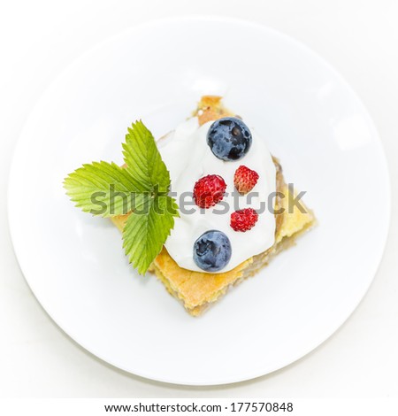 Apple-pie cake with blueberies and wild strawberry with cream