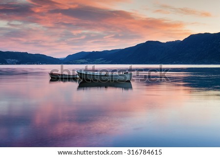 Two lonely boats on calm water of fjord. Norway.