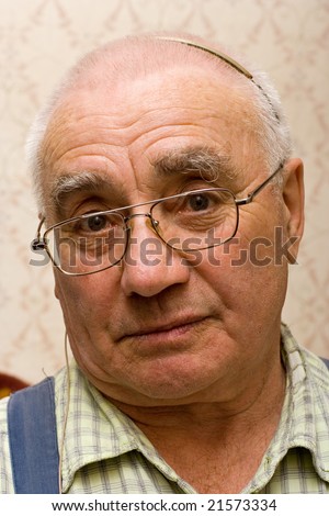 Elderly man in glasses with hearing-aid