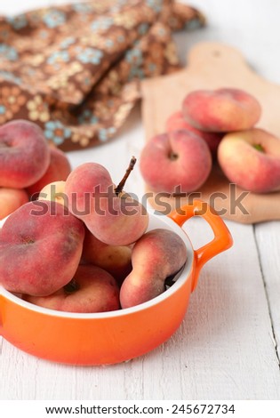 peach figs in a ceramic bowl on a white background