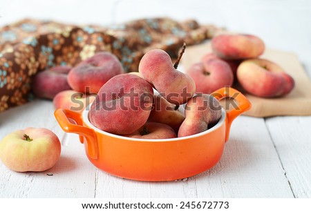 peach figs in a ceramic bowl on a white background