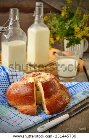 Bun with butter and milk. Breakfast in rustic style. Selective focus