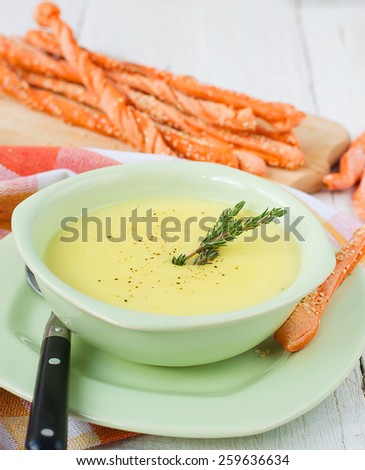 Potato and garlic cream soup with bread sticks