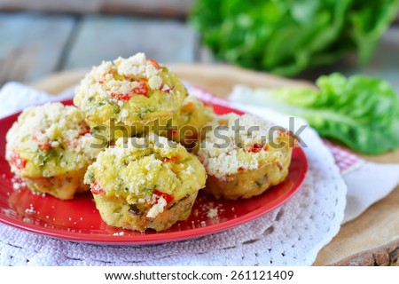 zucchini muffins with red pepper on a wooden background