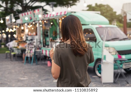 Young asian woman walking in the food truck market