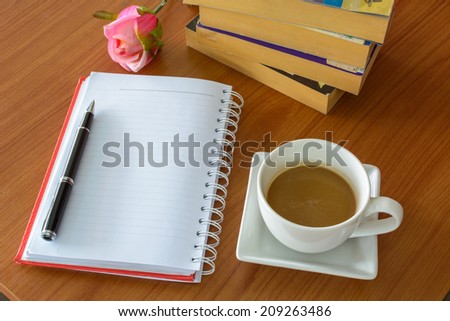 cup of coffee with notebook and flower