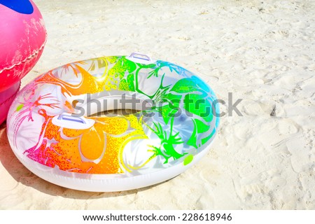 colorful swim ring on white sand beach