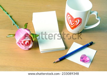 Cup of coffee with blank memo and rose, vintage style