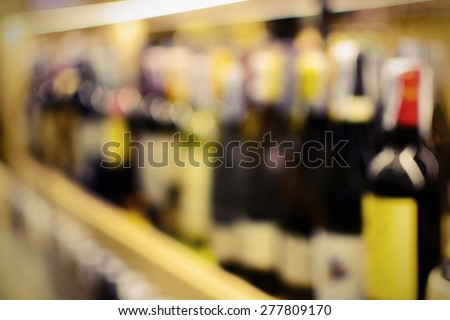 Row of blurred wine bottles at shop
