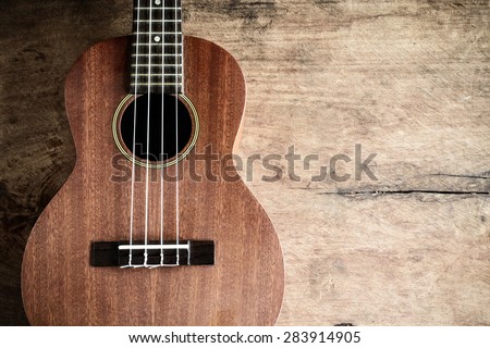 Close up of ukulele on old wooden background, Dark tone