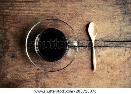 Cup of coffee with wood spoon on old wood textured and background, Vintage tone