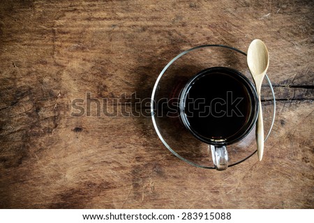 Cup of coffee with wood spoon on old wood textured and background, Dark tone