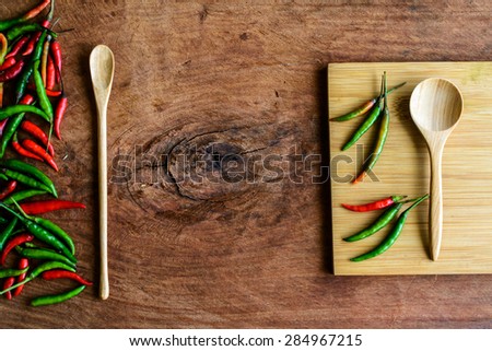 chilli pepper with wood cutting board on old wood background