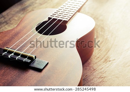 Close up of ukulele on old wood background with soft light, Vintage tone