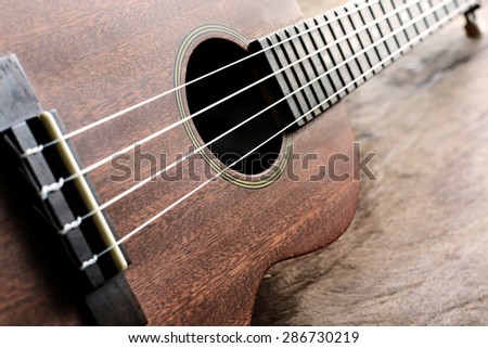 Close up of ukulele on old wood background with soft light, Vintage tone
