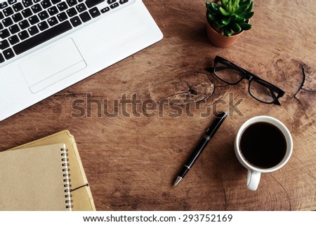 Laptop with notebook and cup of coffee with on old wooden table, Vintage tone