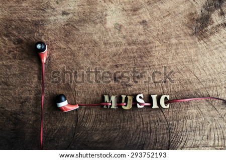 portable audio earphones on old wood textured with word \