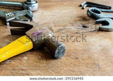 Close up of rusty hammer and tools on old grunge wood background