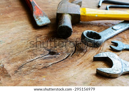 Close up of rusty hammer and tools on old grunge wood background