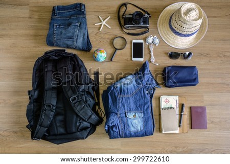 Outfit of traveler on old wooden background