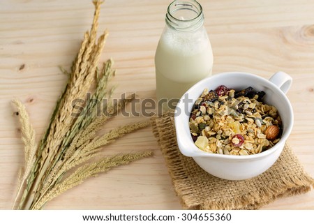 Bottle of fresh milk with Oat and whole wheat grains flake on wooden table
