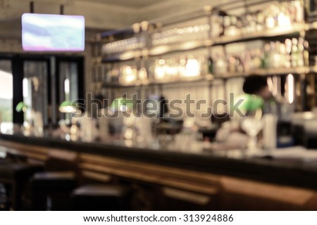 Abstract blurred image of bar counter with bottles of whiskey and wine, Vintage tone