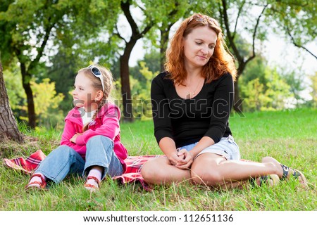sad mother and little daughter having a quarrel, looking in different directions